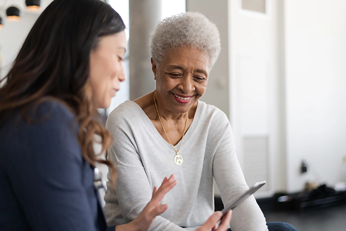 elderly person being shown how to use technology